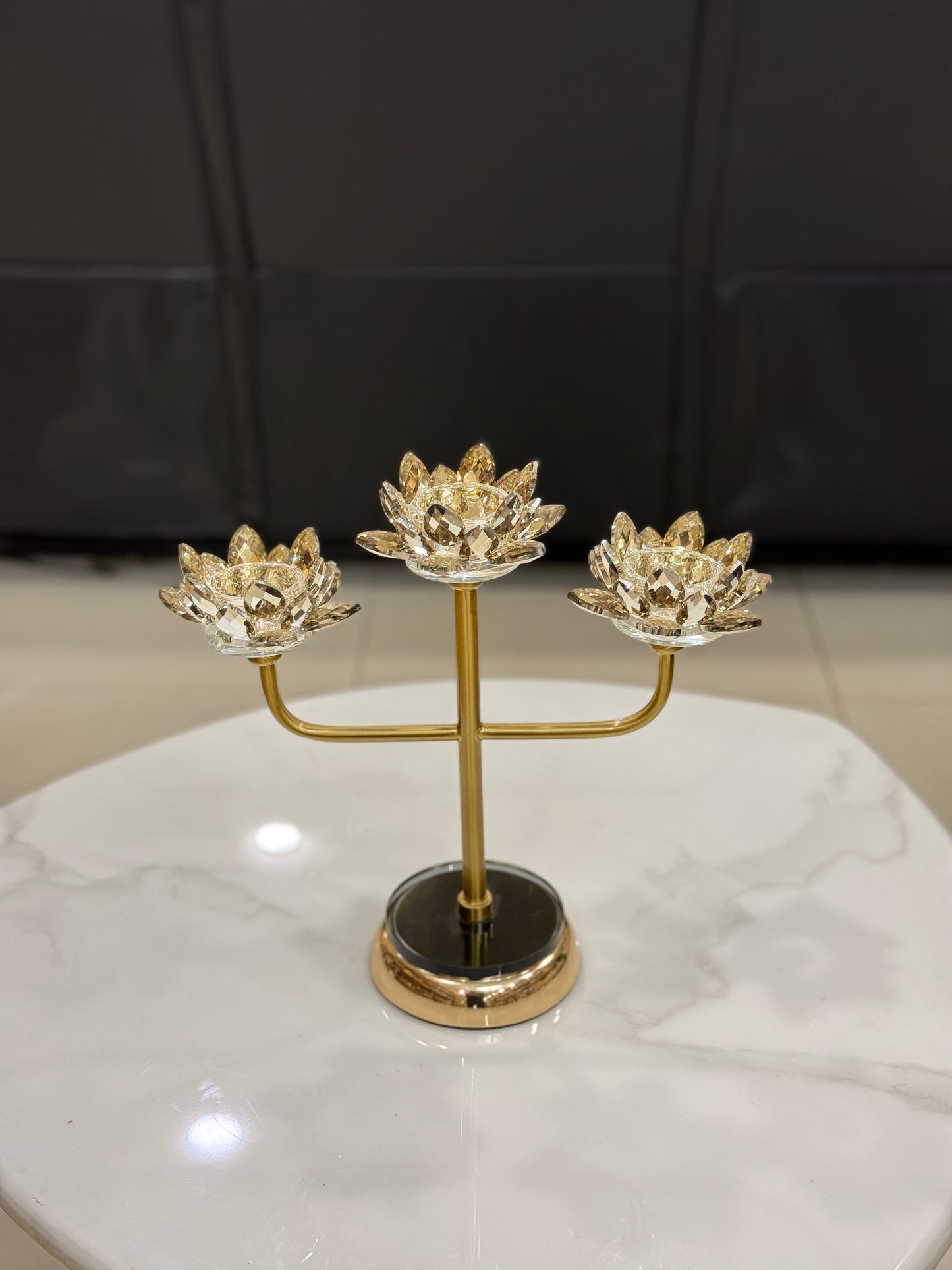 Three-arm gold candelabra with crystal lotus candle holders displayed at Fatima Home Decor store in Islamabad.