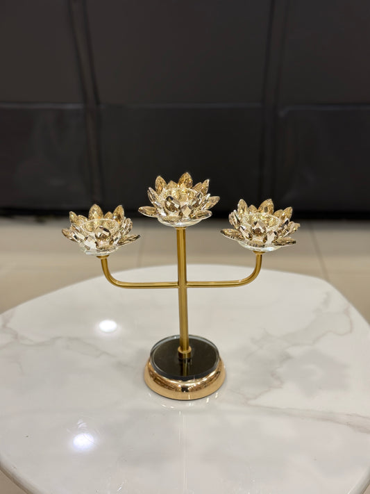 Three-arm gold candelabra with crystal lotus candle holders displayed at Fatima Home Decor store in Islamabad.
