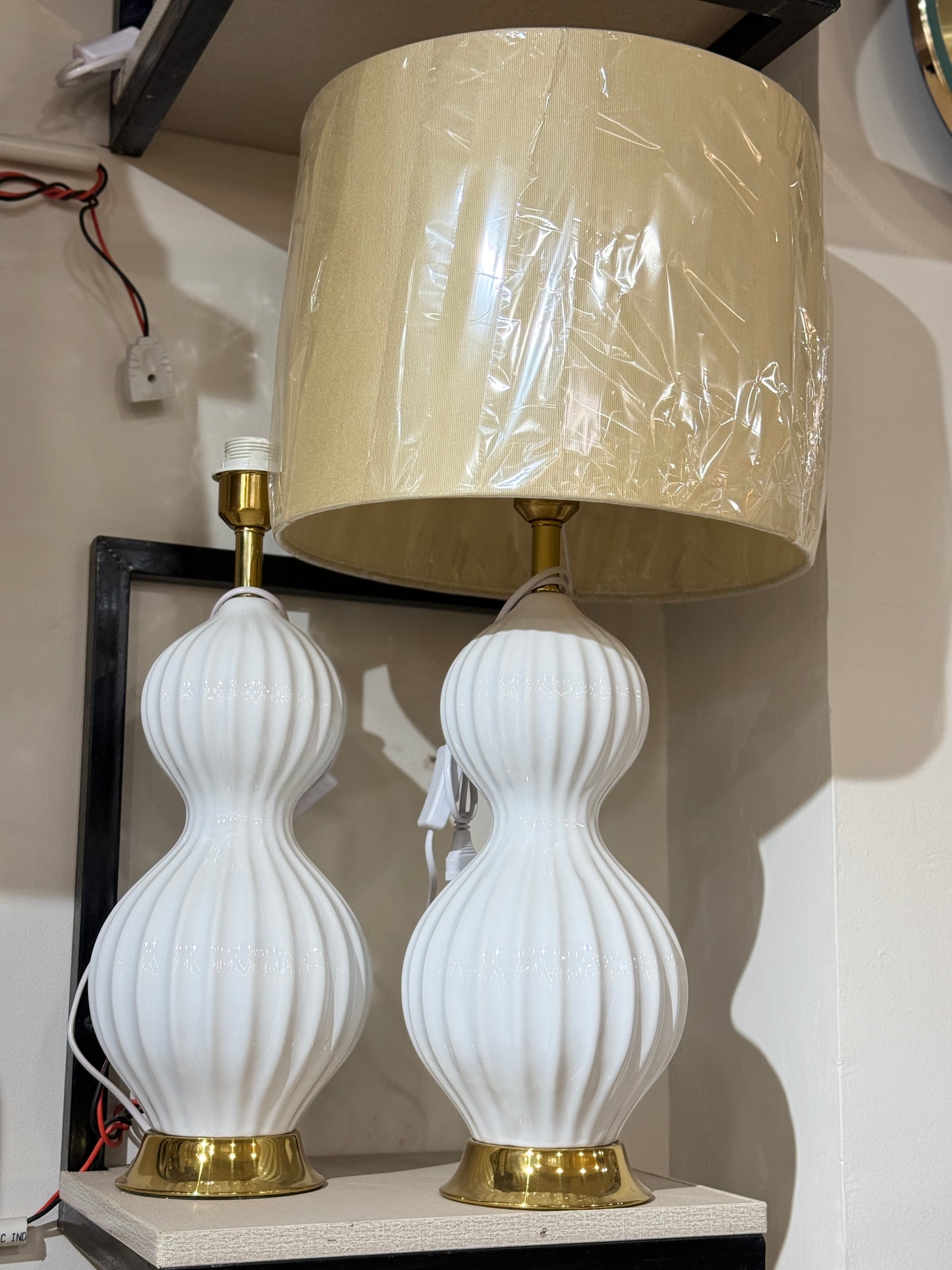 White sculptural table lamp with a ribbed ceramic gourd base and gold pedestal at Fatima Home Décor store in Islamabad.