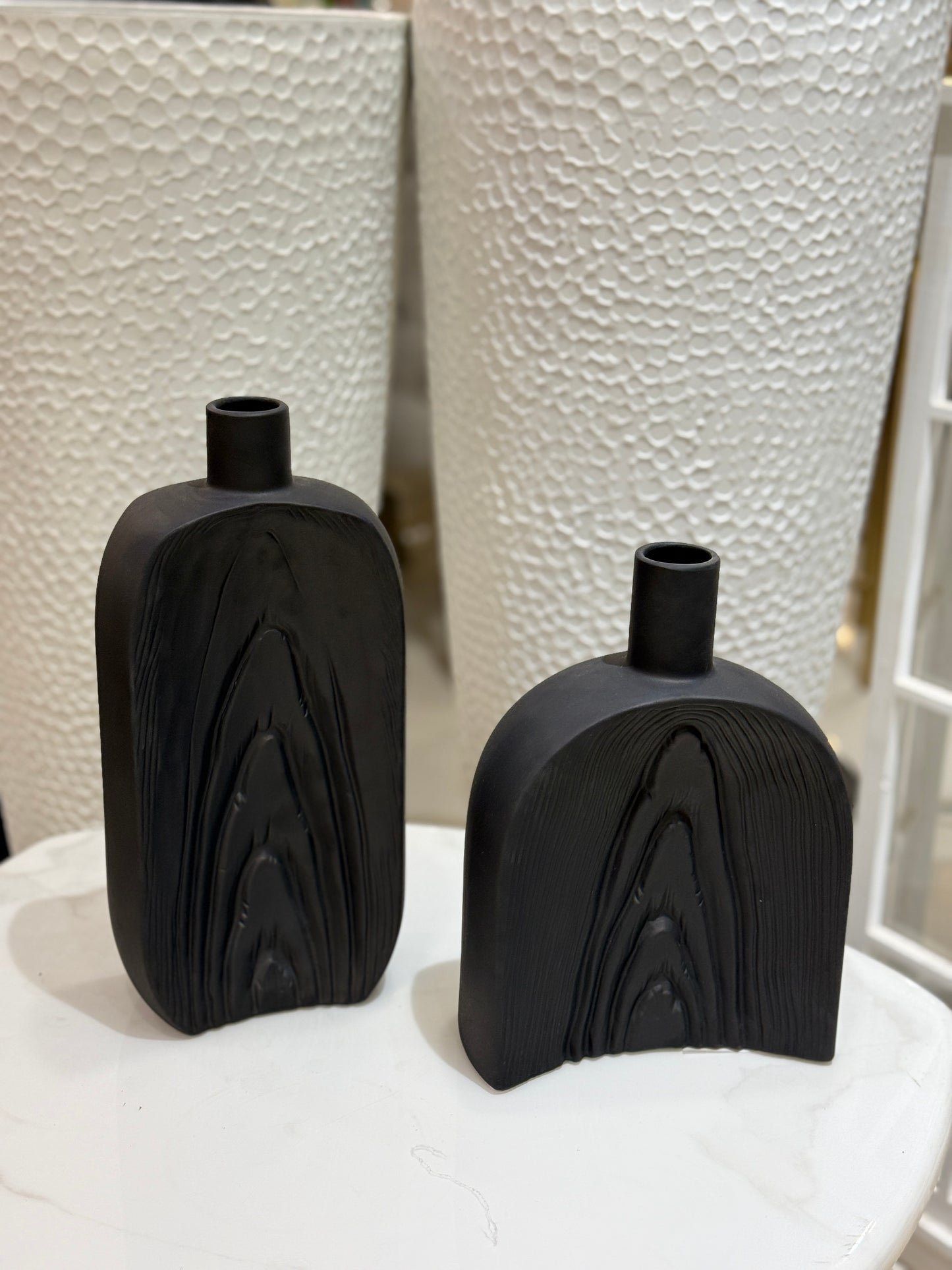 Set of two matte black ceramic vases with vertical wood-grain textures displayed at Fatima Home Décor store in Islamabad.