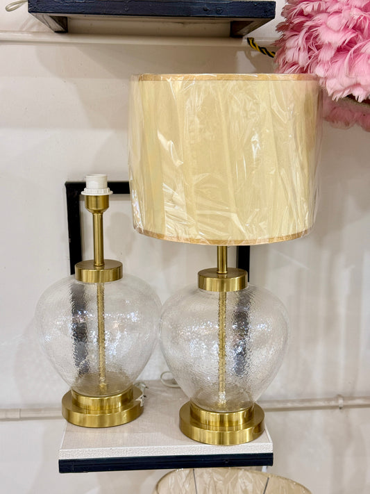 Modern table lamp with a textured clear glass orb base and gold pedestal displayed at Fatima Home Décor store in Islamabad.